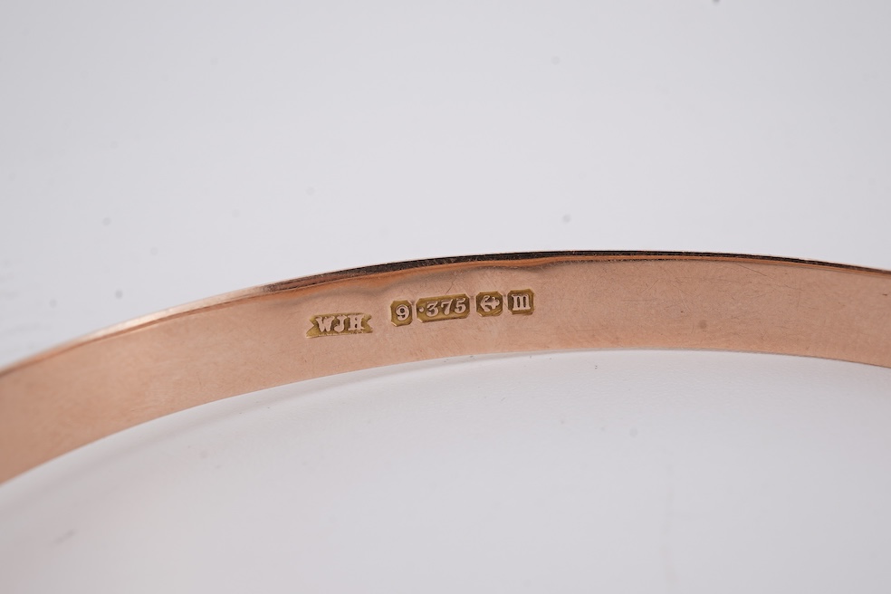 A George V part engraved 9ct gold hollow hinged bangle, Birmingham, 1911, interior diameter 57mm, 5.5 grams. Condition - poor